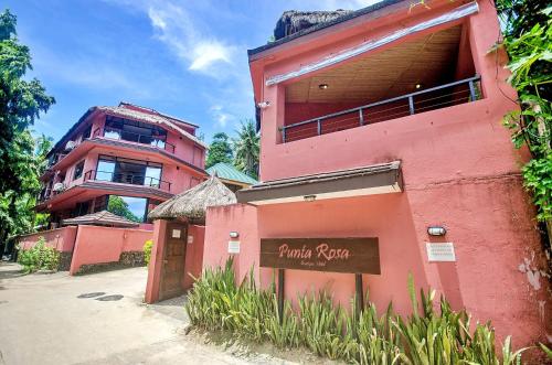 um edifício cor-de-rosa com uma placa à frente. em Signature Boracay Punta Rosa formerly Punta Rosa Boutique Hotel em Boracay