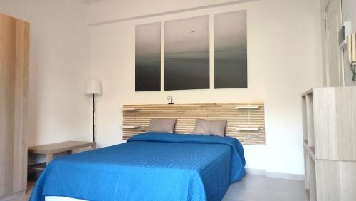 ein Schlafzimmer mit einem blauen Bett und einem Fenster in der Unterkunft La Ninfa in Acitrezza