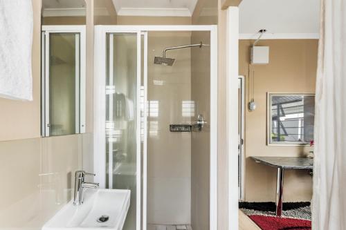 a bathroom with a glass shower and a sink at Sort after Cape Town home. Welcome to Judah house. in Cape Town