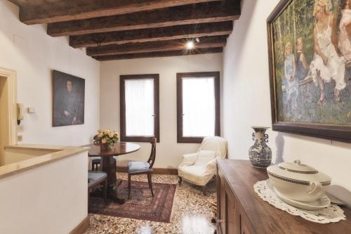 a living room with a table and a painting on the wall at Palazzetto San Lio, Rialto in Venice