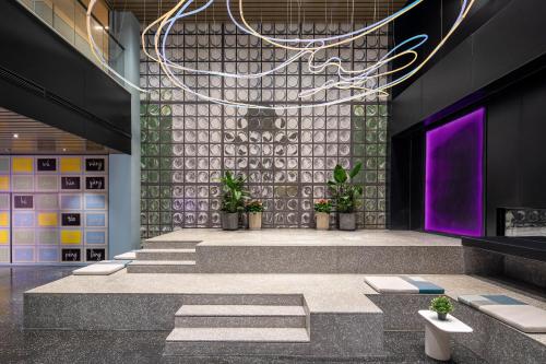 a lobby with a row of stairs and purple lights at lyf by Ascott Hongqiao Shanghai NECC in Shanghai