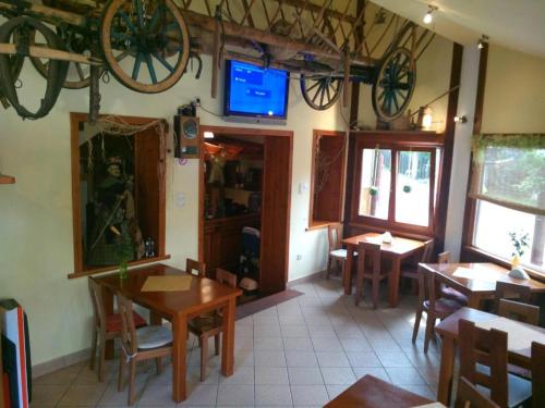 ein Restaurant mit Tischen und Stühlen und einem TV an der Wand in der Unterkunft Gościniec Halka in Zwardoń