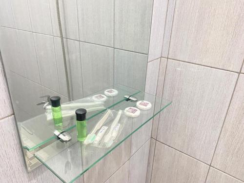- une étagère en verre dans la salle de bains pourvue d'un miroir dans l'établissement MJ Guest House Pusat Kota Malili Mitra RedDoorz, à Malili
