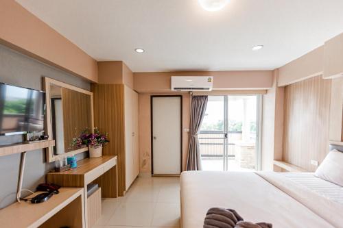 a hotel room with a bed and a television at Latin Garden Hotel in Bangkok