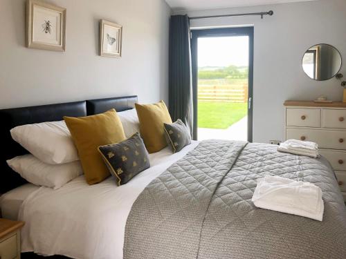 a bedroom with a bed with yellow pillows and a window at The Old Dairy - Uk31253 in Middleton