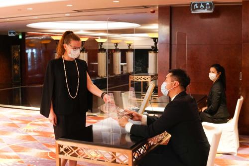 a woman and a man in face masks standing around a table at Grand Hyatt Hong Kong in Hong Kong