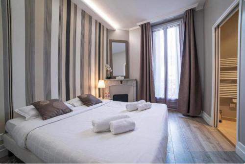 a bedroom with a large white bed with towels on it at Superbe 120m2 au Suquet - Property With Style in Cannes