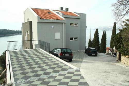 a house with two cars parked in front of it at Apartments Didan in Cavtat