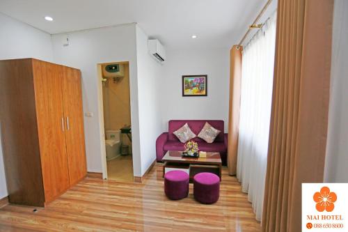 a living room with a purple couch and a table at Mai Hotel My Dinh 미딩 in Hanoi