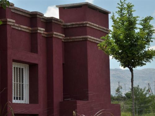 a red building with a tree in front of it at Casonas de Nono in Nono