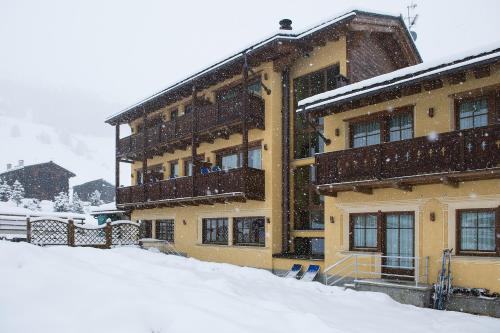 a building with snow on the ground in front of it at Hotel Valtellina in Livigno