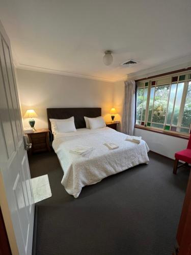 a bedroom with a large bed and a window at JOHN HUNTER B&B in Lambton