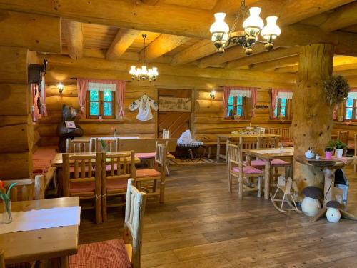a dining room in a log cabin with tables and chairs at Srub u Medvěda in Nový Jičín