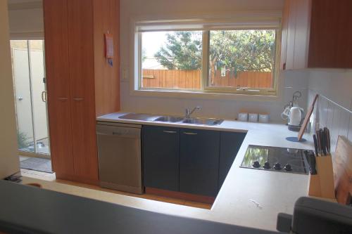 una cucina con lavandino e finestra di Beachside Haven at Cowes a Cowes