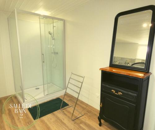 a bathroom with a shower and a dresser with a mirror at L'authentique Martelaise PISCINE CHAUFFEE in Martel