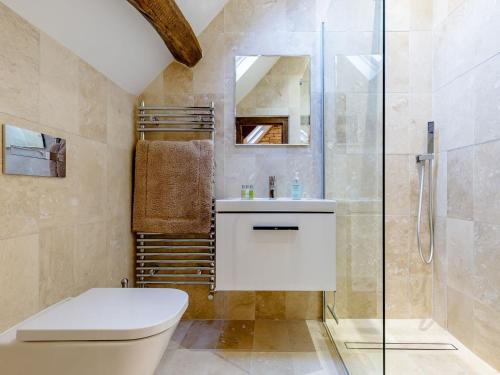 a bathroom with a shower and a toilet and a sink at Kilcot Coach House in Hillsley