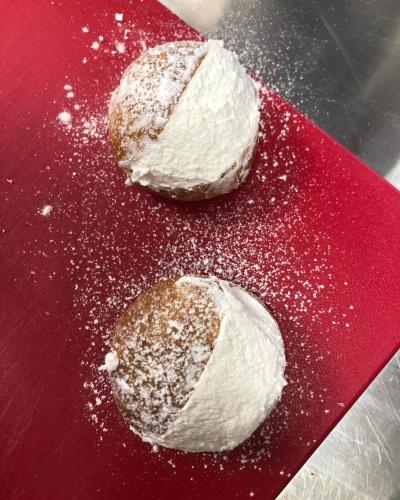 two powdered donuts sitting on a red plate at mammaCristina in Patti