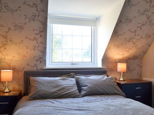 a bedroom with a bed with two lamps and a window at The Nest in York