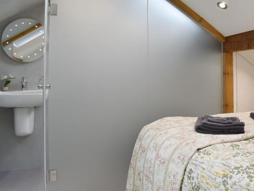 a bathroom with a bed and a sink at Fern Cottage in Bradwell