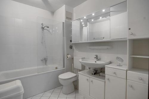 a white bathroom with a toilet and a sink at SaßStähler, FW6 in Zingst