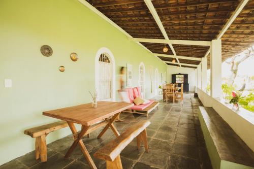 een eetkamer met een houten tafel en banken bij Villa Ostello Pousada in Paripueira