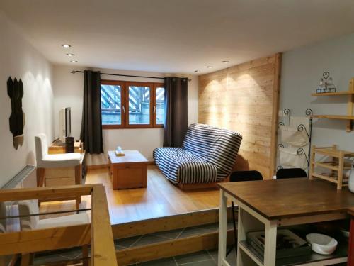 ein Wohnzimmer mit einem Sofa und einem Tisch in der Unterkunft Coquet T1 hyper centre in Le Bourg-dʼOisans