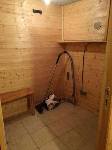 - une salle de bains avec un aspirateur dans un mur en bois dans l'établissement Coquet T1 hyper centre, au Bourg-dʼOisans