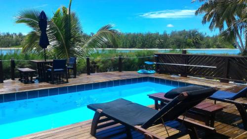 - une piscine avec des chaises et des tables à côté d'une terrasse en bois dans l'établissement Sokala Villas, à Muri