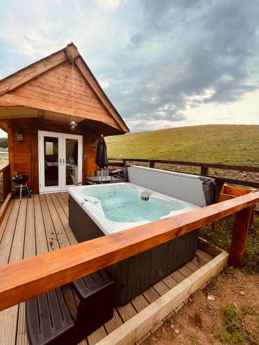 a hot tub on the deck of a house at East Learmouth Lakeside Lodges in Cornhill-on-tweed