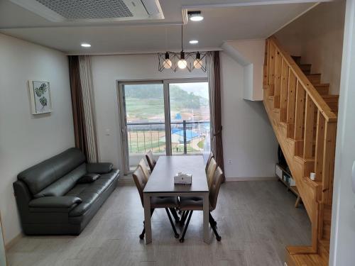 a living room with a table and a couch at Secret Garden Pension in Yeosu