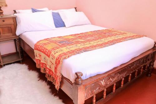 a bedroom with a bed with a blanket on it at Nyahururu Highlands Heaven -BnB in Nyahururu