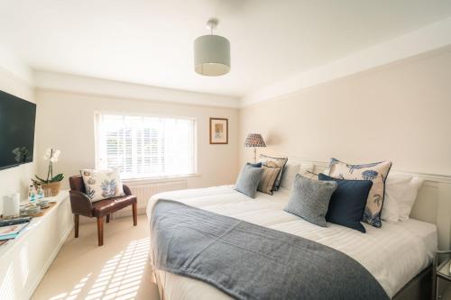 a bedroom with a large bed with blue pillows at The Seaview, East Preston in Littlehampton