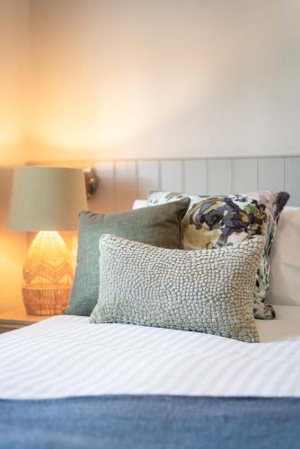 a bedroom with a bed with pillows and a lamp at The Seaview, East Preston in Littlehampton