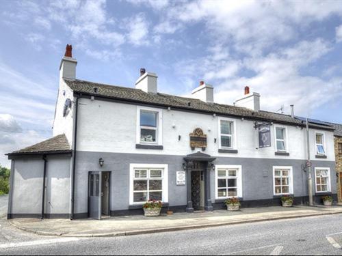 a large white building on the side of a street at Masons Freehouse in Ingleton