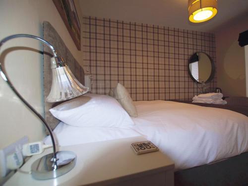 a hotel room with a bed and a lamp on a desk at Masons Freehouse in Ingleton