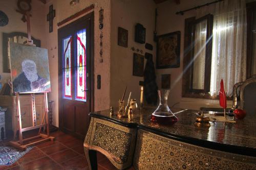 Zimmer mit Tisch und Wandgemälde in der Unterkunft Chateaux Constantin Agistro in Ángistron