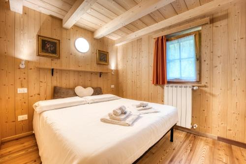 a bedroom with a large bed in a wooden room at Incanto Walser Apartments Testa in Macugnaga