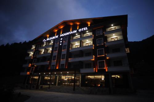PAZARCIK MOUNTAIN HOTEL في طرابزون: مبنى عليه علامة في الليل