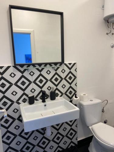 een badkamer met een wastafel, een toilet en een spiegel bij Apartment Ana in Vis