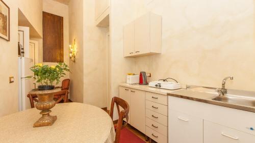 una pequeña cocina con mesa y fregadero en Domus Minervae, en Roma