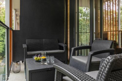 a patio with chairs and a table with fruit on it at Pobierowo Plaża & SPA - Apartament na Wydmach by Noclegi Renters in Pobierowo