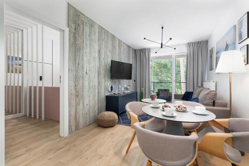 a living room with a table and chairs at Pobierowo Plaża & SPA - Apartament na Wydmach by Noclegi Renters in Pobierowo