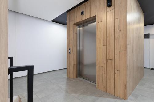 a elevator with a wooden door in a room at Pobierowo Plaża & SPA - Apartament na Wydmach by Noclegi Renters in Pobierowo