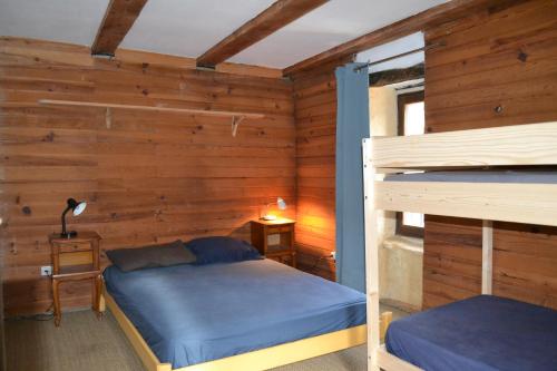 a bedroom with two bunk beds in a room with wooden walls at Gîte de Fontfouillouse in Les Plantiers