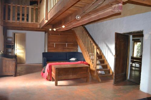a bedroom with a bed and a wooden staircase at Gîte de Fontfouillouse in Les Plantiers