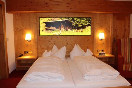 1 dormitorio con 1 cama con 2 almohadas blancas en Zum Eichhof, en Reit im Winkl