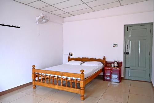 1 dormitorio con cama y puerta verde en GiriDarshini Homestay - Pool, Falls, 3BH, Home Food & Estate en Chikmagalūr