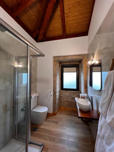 La salle de bains est pourvue de 2 lavabos et d'une douche. dans l'établissement Recanto de Moulães, à Monção