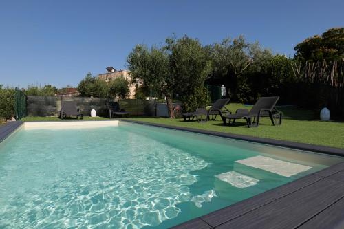 een zwembad met blauw water in een tuin bij Il Borgo Delle Querce Villa Fichi Piscina privata in Martina Franca
