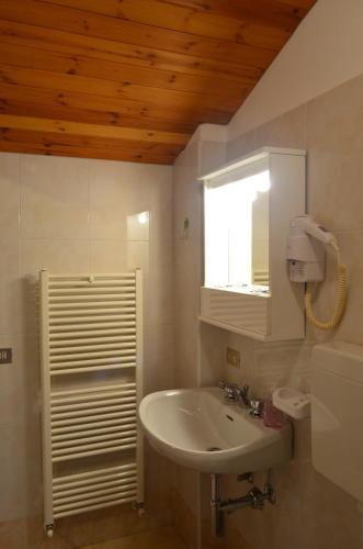 a bathroom with a sink and a mirror and a window at Campodolcino Camping in Campodolcino